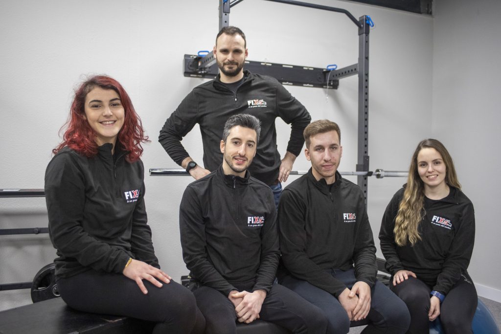 Imagen del equipo de entrenadores posando para la foto oficial de nuestra clínica sonriendo de forma distendida en la sala de entrenamiento.